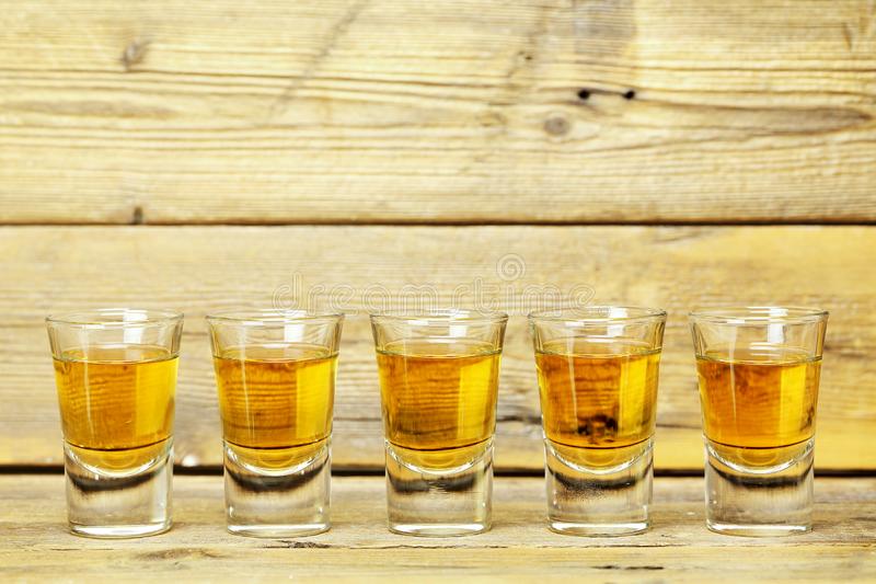 five-whiskey-shots-weathered-wooden-planks-whiskey-shots-125359439.jpg