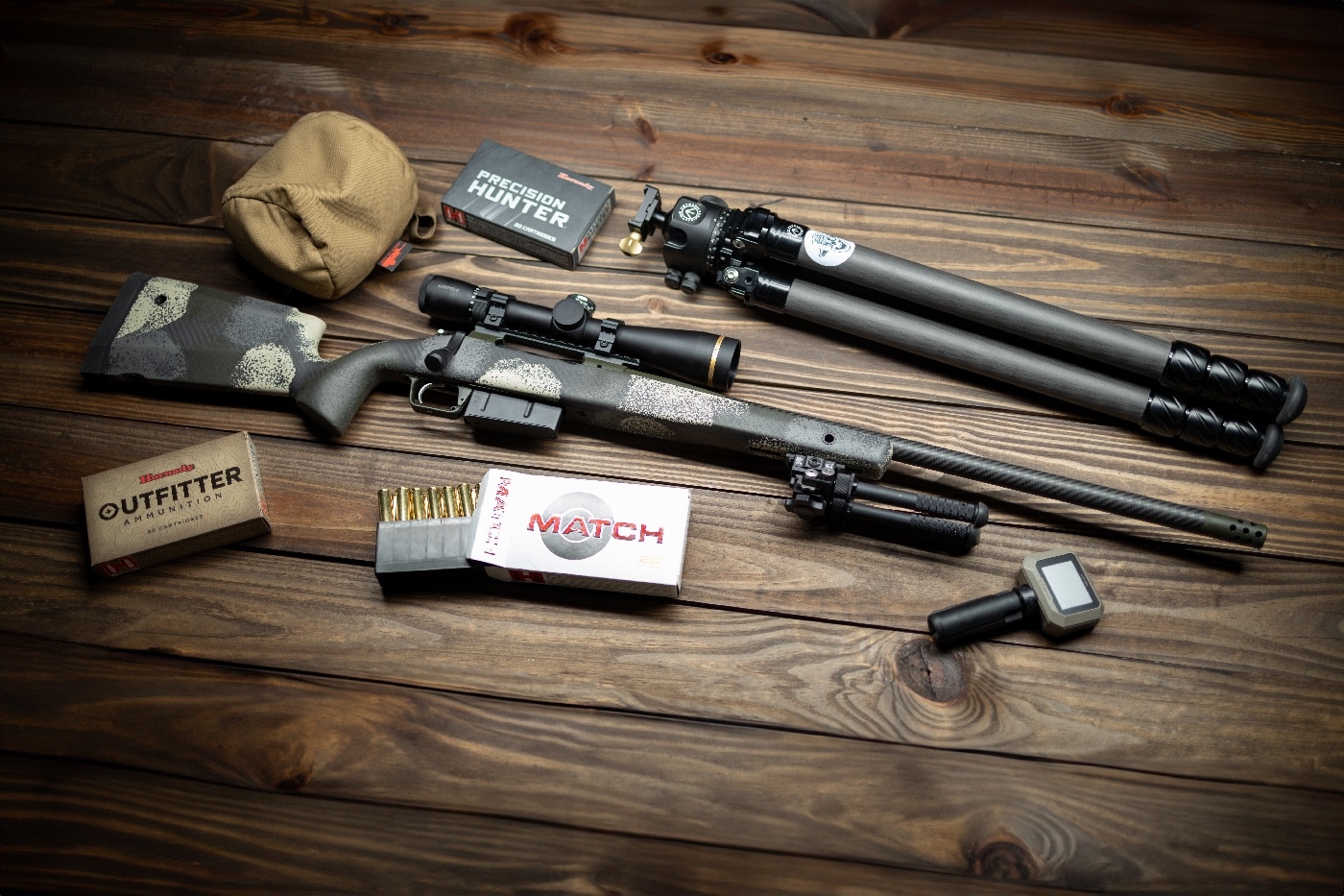 In this photo we see the new Springfield Armory Model 2020 Long Action Waypoint rifle and shootiung accessories including ammo and a tripod. The new gun is available in .270 Winchester, .30-06 Springfield, 7mm Remington Magnum, .300 Winchester Magnum, 7mm PRC, .300 PRC cartridges ammunition.