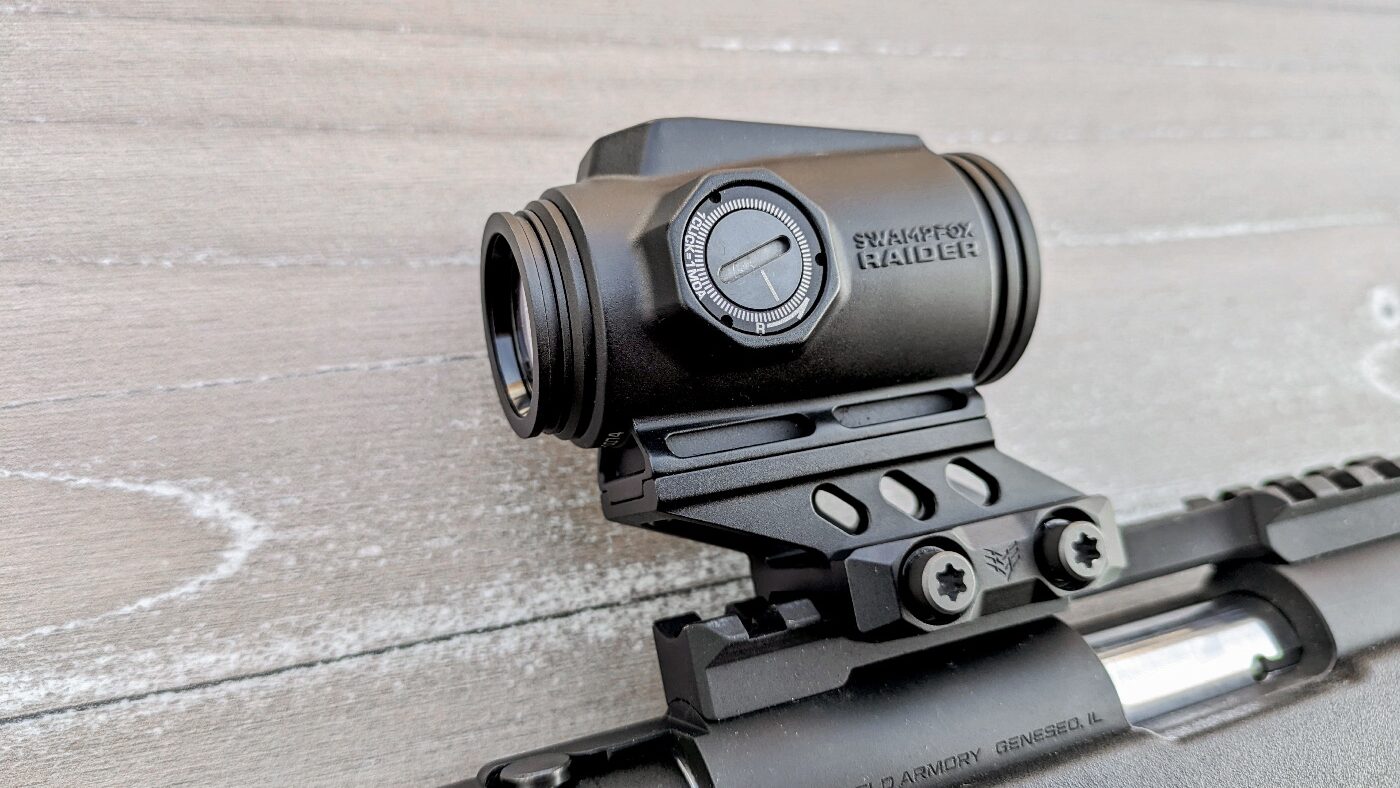 We see the Raider 1x micro prism sight mounted to the Picatinny rail of the Springfield Armory Model 2020 Rimfire rifle. It uses a riser to bring the 1x prism to eye level. It can also be used on other guns like the AR platform rifles while offering potentially better value than expensive sights like those from Aimpoint or the Trijicon ACOG.