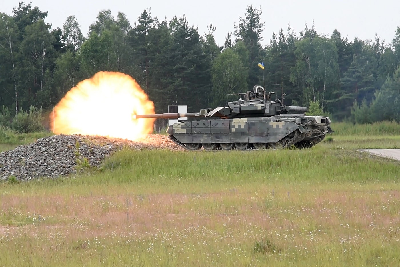 In this photograph we see the massive fireball around the muzzle of the main gun as a T-84 tank fires it  during training.