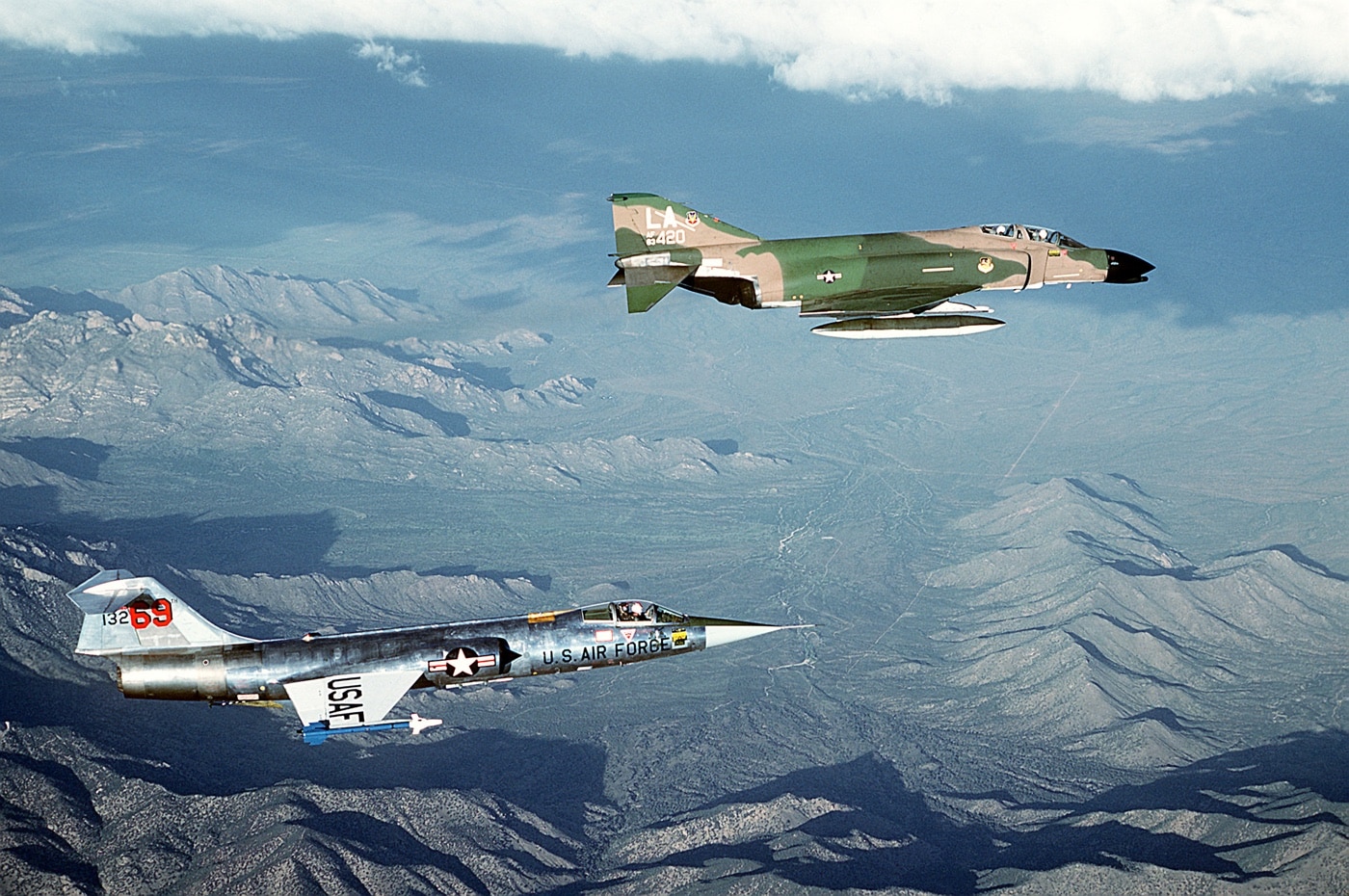 Here we see the classic F-104 in flight along with the more modern McDonnell Douglas F-4 Phantom II. Both air force fighters were well known for their high speed capabilities.