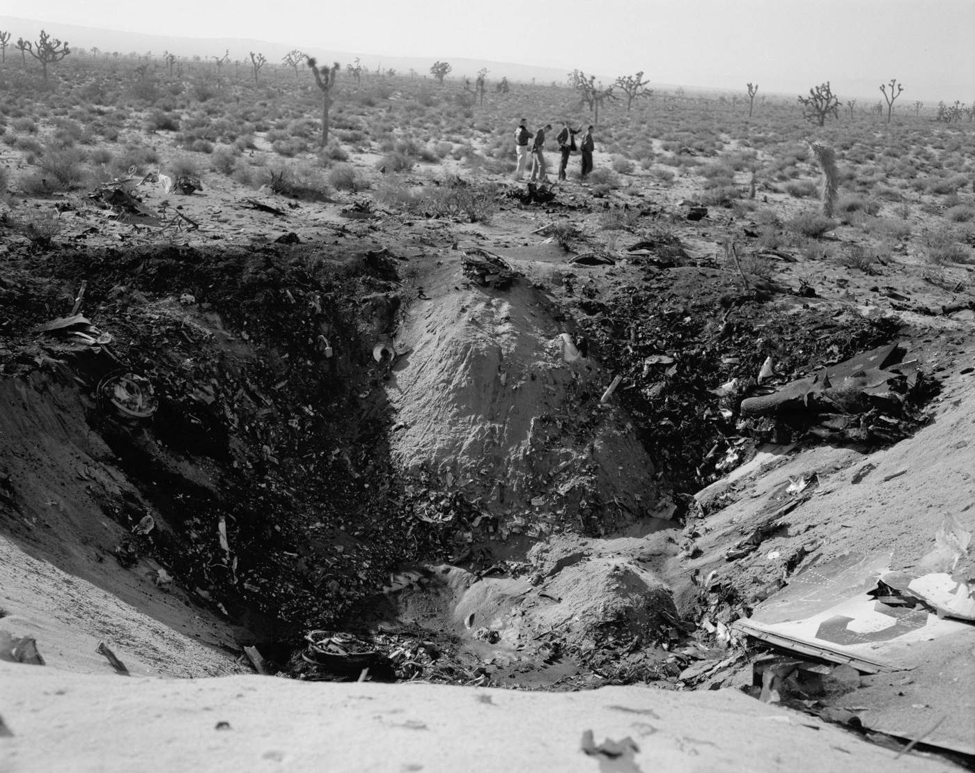 In this B&W photo, we see the site of the nose-first, high-impact JF-104A crash that left this large crater near Edwards AFB in December 1962. NASA test pilot Milton O. Thompson safely ejected prior to impact.