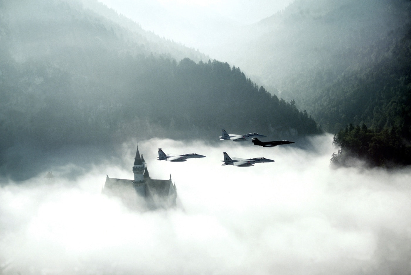 In this photograph, a German Air Force F-104 Starfighter leads a flight of three U.S. F-15 Eagles past Neuschwanstein Castle during REFORGER '82.