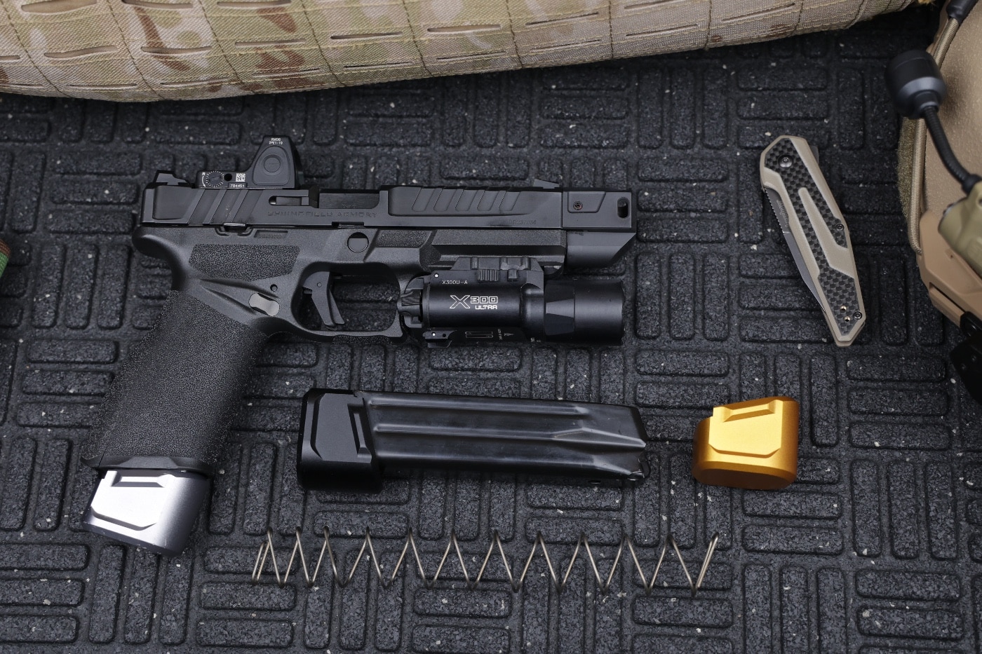 Shown here are the Tyrant CNC upgrade parts for Springfield Echelon firearm. This 9mm pistol is a semi-automatic handgun designed to cire centerfire cartridges from a detachable magazine. A red dot optic and a flashlight are also mounted on the gun for self-defense use and CCW.