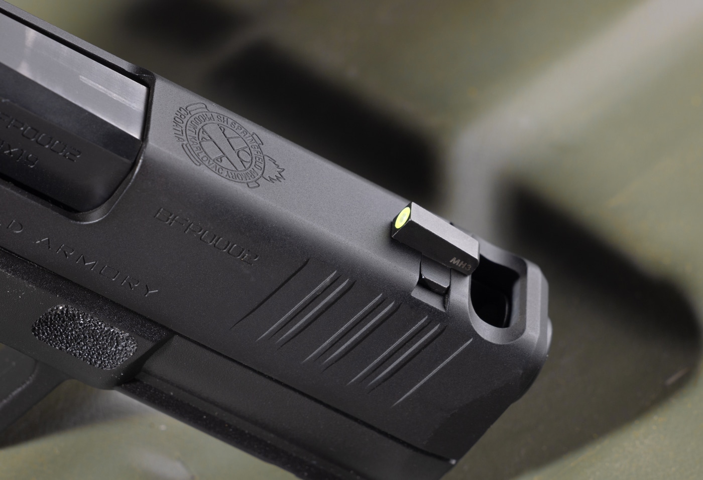 In this photo we see a close up photo of the ported barrel and slide on Springfield Hellcat Pro Comp. We also see the front sight, these iron sights are the U-Dot sight designed for concealed carry and self-defense.