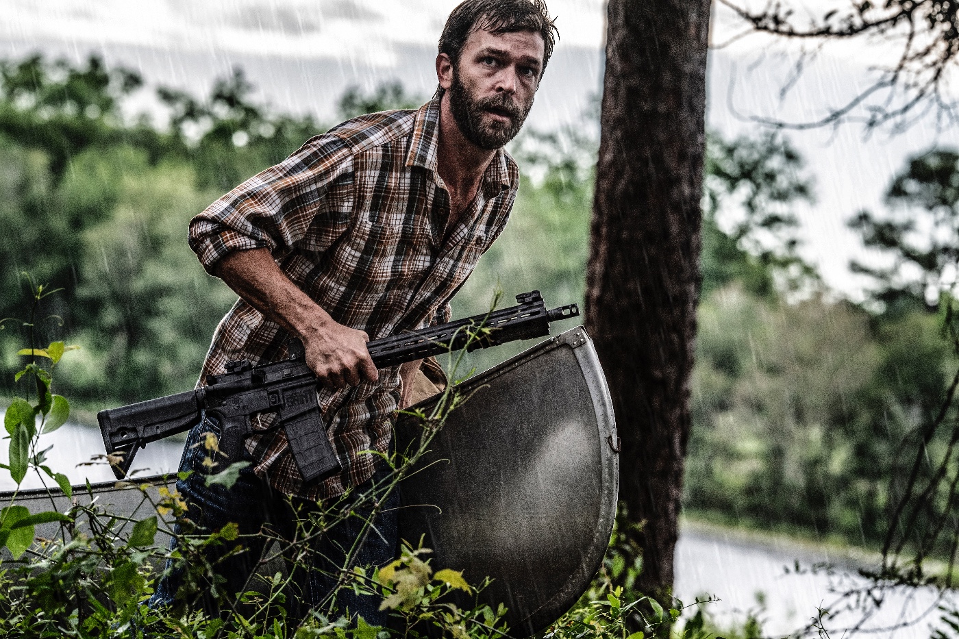 Shown here is a prepper with Springfield SAINT rifle as he pulls his canoe out of the river. Complete prepping involves preparing for a wide range of threats — from job loss to major catastrophe. Firearms are a realistic portion of comprehensive preparations.