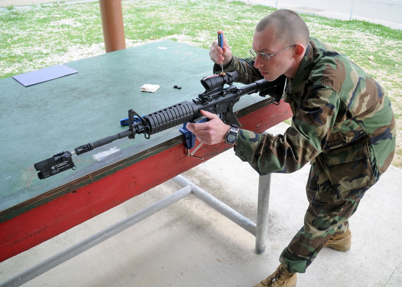 US Navy sailor bore sights an ACOG on an M4 carbine