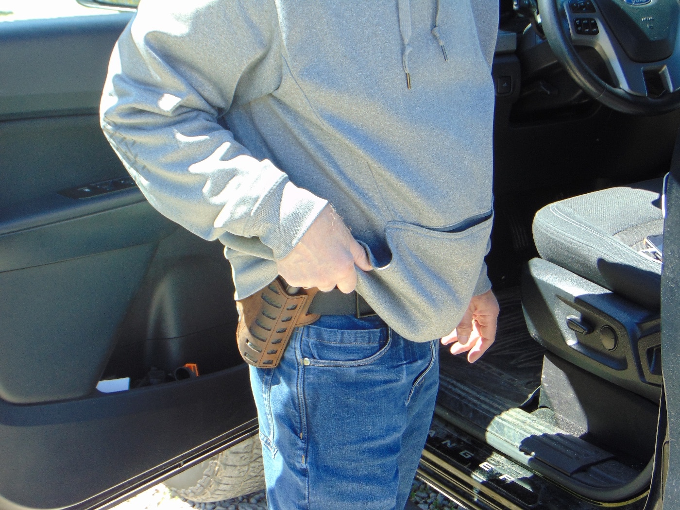 In this photograph, the author demonstrates exposing a holstered firearm. Is it an accident or a threat? Perception of the witnesses is important.