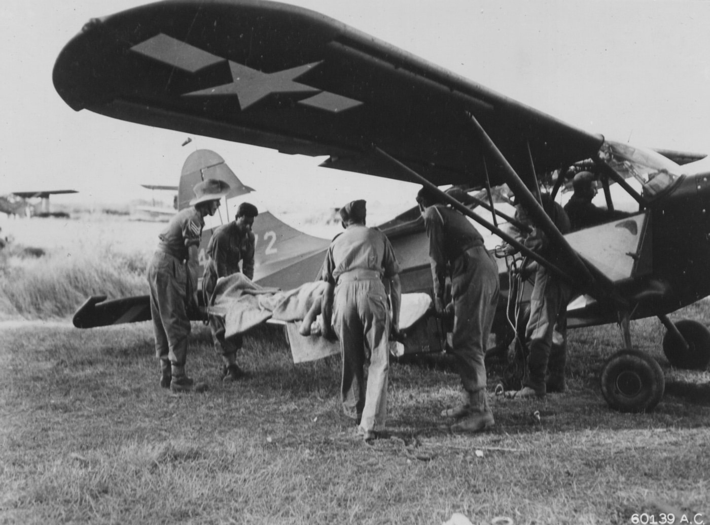 wounded British soldier loaded on Vultee L-5 plane for medical evacuation