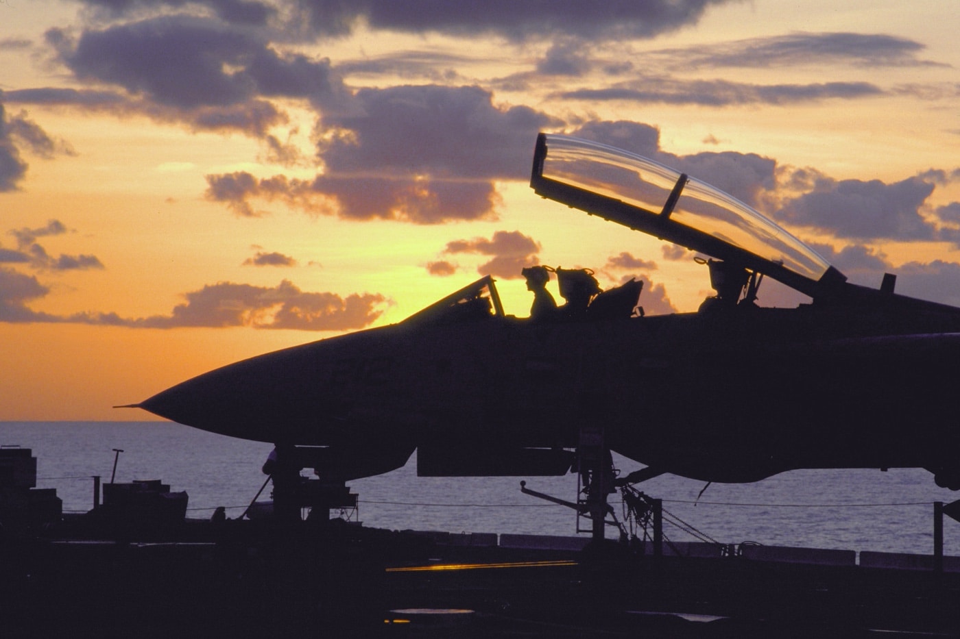 technicians inspect an F-14 on the USS Kitty Hawk