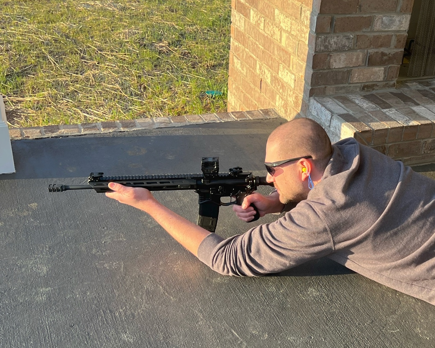 author shooting Springfield Armory SAINT rifle from prone position at shooting range