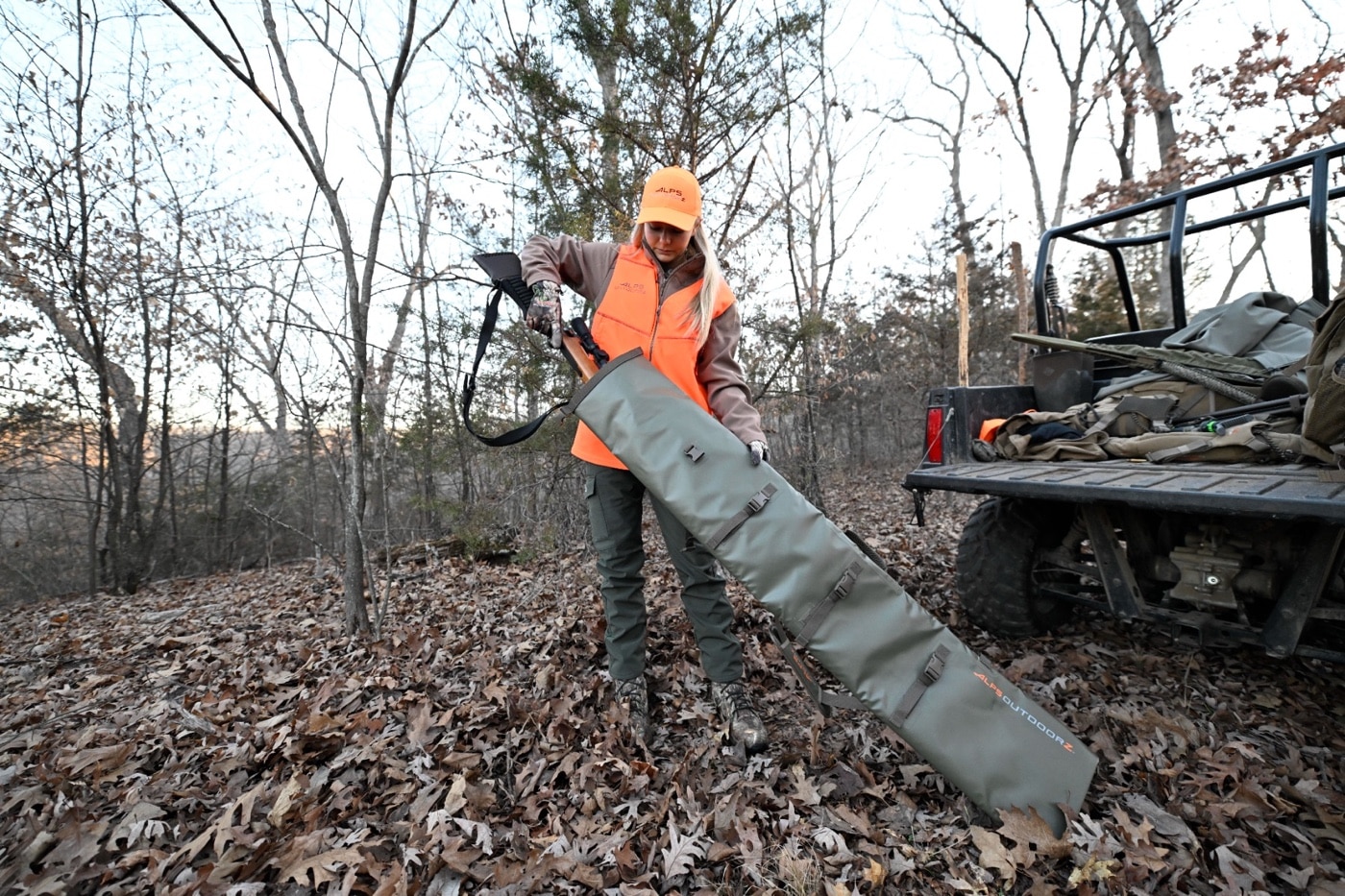 hunter with Alps Outdoorz Waterproof Rifle Case testing how well the case protects her rifle