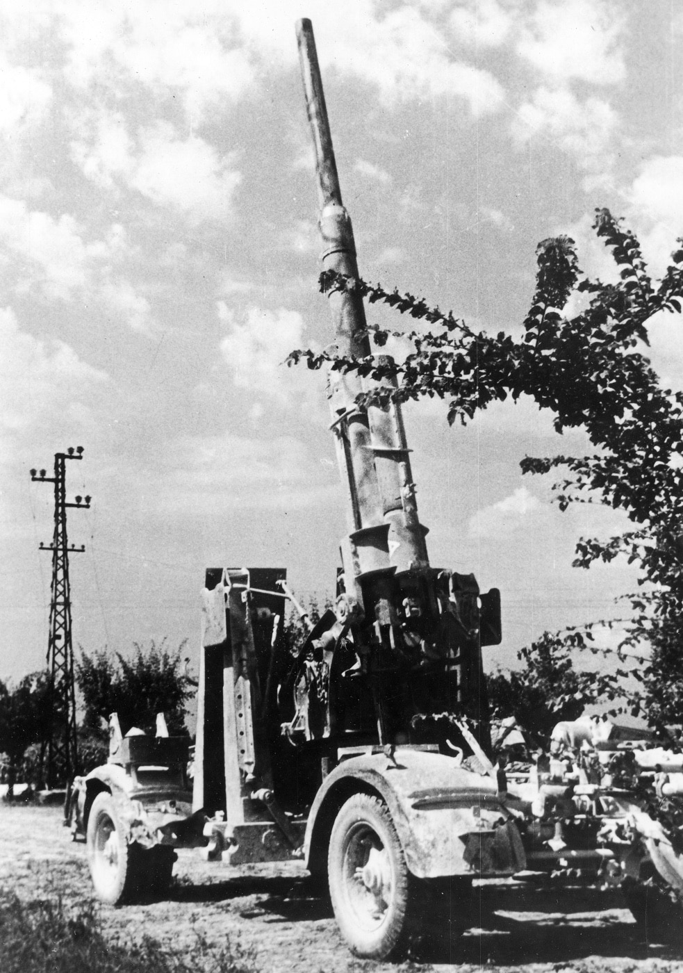 A German Flak 41 88mm gun is shown with its barrel elevated, ready to engage Allied aircraft during World War II. Designed for high-altitude anti-aircraft defense, the Flak 41 boasts increased range and firepower compared to earlier models. The imposing weapon’s angular design emphasizes its advanced engineering and effectiveness against aerial threats. This image highlights the Flak 41’s critical role in Germany’s efforts to counter Allied air superiority.