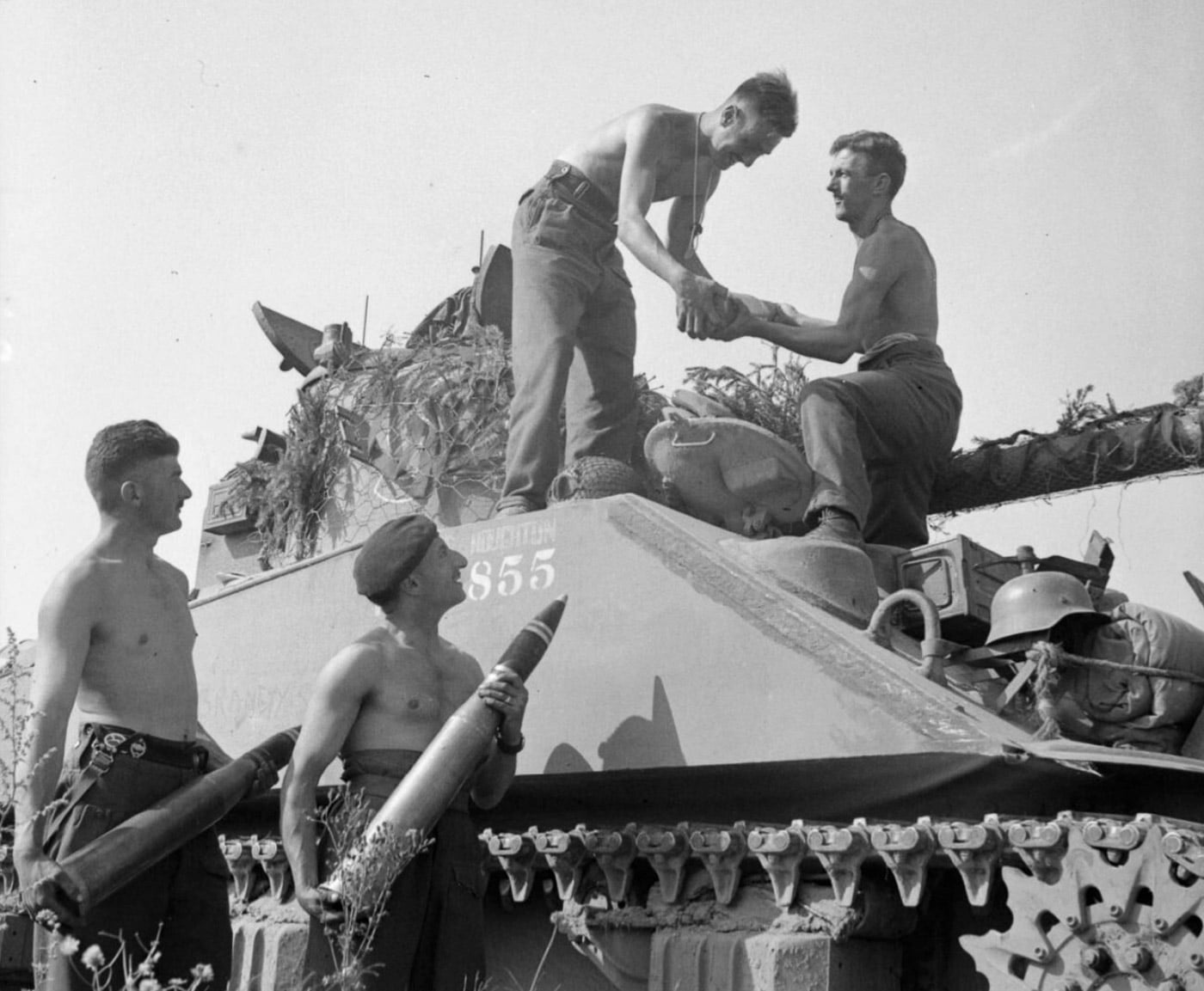 British soldiers load 75 pounder ammunition into a Sherman Firefly