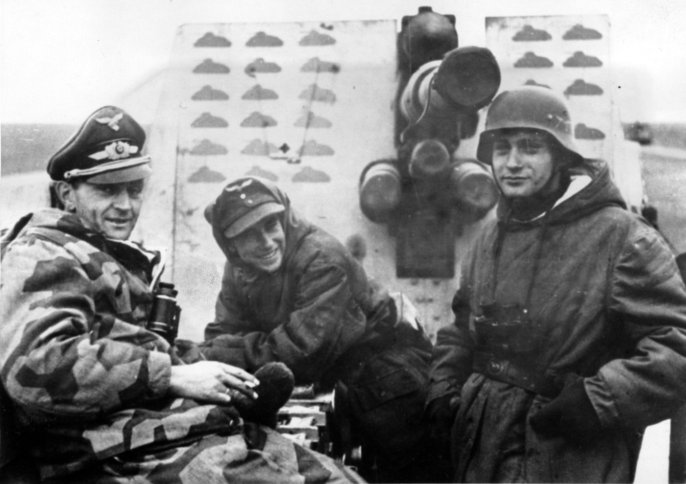 A German Luftwaffe crew poses in front of an 88mm gun stationed on the Eastern Front during World War II. The gun shield prominently displays painted marks, each representing a Russian tank destroyed in combat. The soldiers stand confidently, reflecting the weapon’s effectiveness and their role in its operation. This image captures the 88mm gun’s reputation as a formidable tank-killer in the harsh conditions of the Eastern Front.