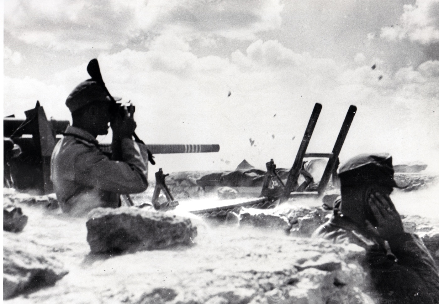 German soldiers fire an 88mm gun at Halfaya Pass during Operation Battleaxe in Egypt, June 1941. The gun is positioned to repel advancing British forces, demonstrating its lethal precision against tanks. Notable “kill rings” on the gun barrel symbolize its success, with Rommel’s forces destroying nearly 90 British tanks during the engagement. This photo reflects the decisive role of the 88mm in halting British advances in North Africa.