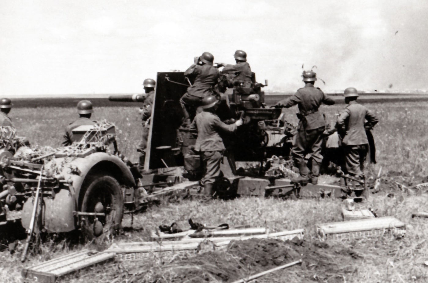 German soldiers prepare to fire an 88mm gun during Operation Barbarossa in the summer of 1941. The gun's exceptional anti-tank capabilities made it essential against Soviet heavy tanks on the Eastern Front. This image illustrates the constant demand for these weapons, highlighting that there were never enough to supply every unit in need. The determined faces of the soldiers emphasize the crucial role these guns played in the campaign.