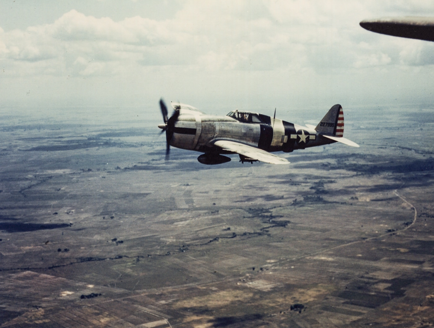 A Republic P-47 Thunderbolt, loaded with bombs, stands ready for a critical strike in the Philippines during World War II. Known for its versatility, the Thunderbolt excelled in both air combat and ground attack missions.