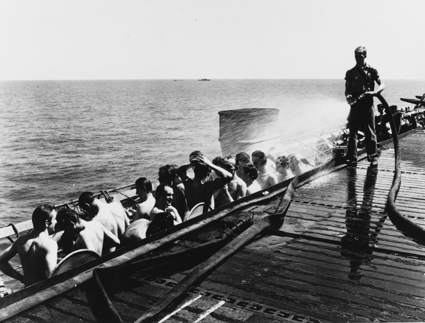 USS Abnaki ATF-96 tows U-505 while German sailors are cooled off with water hose on USS Guadalcanal