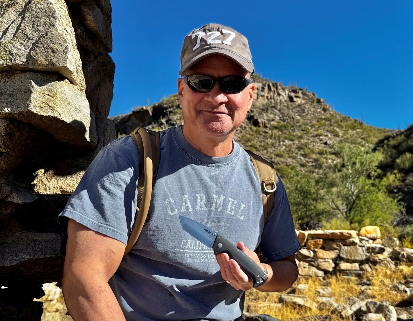 The author pictured during a hike, carrying the Cold Steel AD-10 folding knife, emphasizing its suitability for outdoor adventures. The knife's durable construction and ergonomic handle make it an excellent choice for tackling tasks in the wild. Its compact size ensures it remains lightweight and comfortable for all-day carry. This Cold Steel AD-10 review discusses its performance, best uses, and cutting performance for outdoor enthusiasts.