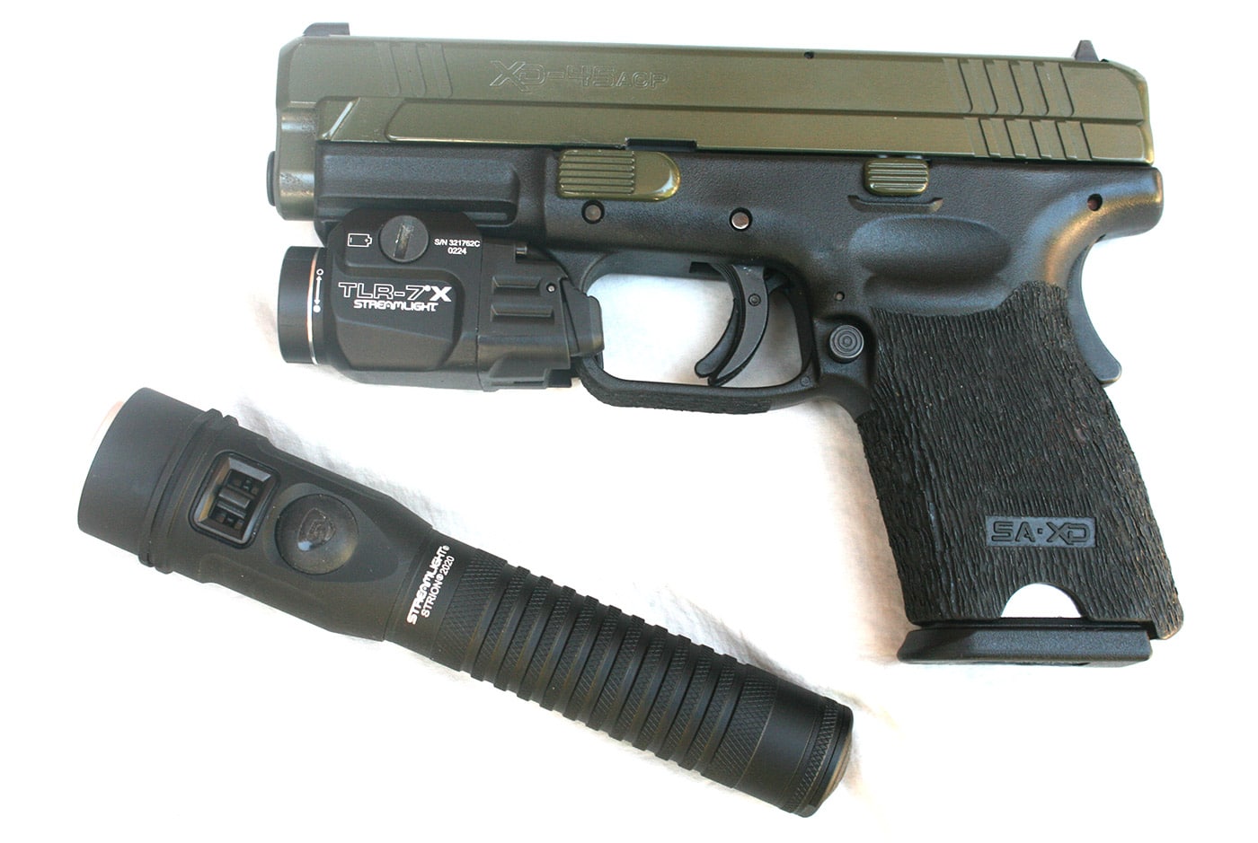 Shown here is the author's Springfield Armory XD 45 semi-automatic pistol with the Streamlight Strion 2020 flashlight. The author believes if you conceal carry a handgun or other firearm you should always have a flashlight with you to identify potential threats. His XD pistol is chambered for the .45 ACP cartridge and has a modified grip and slide. It is also fitted with a Streamlight TLR-7X tactical light.