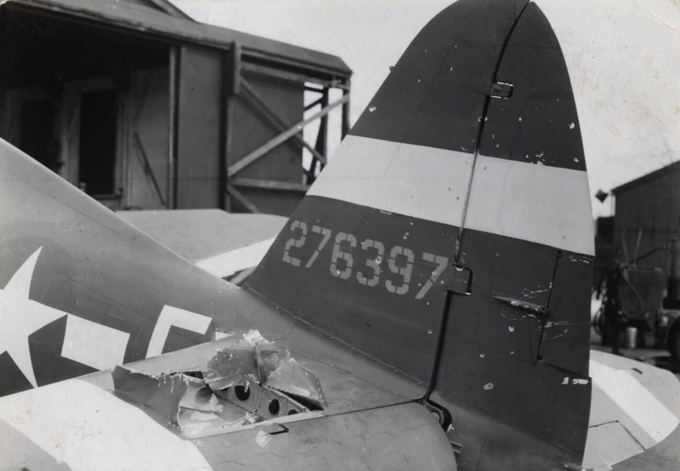 The horizontal stabilizer of a Republic P-47 Thunderbolt shows clear signs of battle damage, with jagged edges and missing sections. This visible wear speaks to the intense engagements these aircraft endured in World War II. Despite the hits, the Thunderbolt’s durability often kept it in the fight and brought its pilots home safely. This image underscores the resilience of both the aircraft and the crews who flew them.