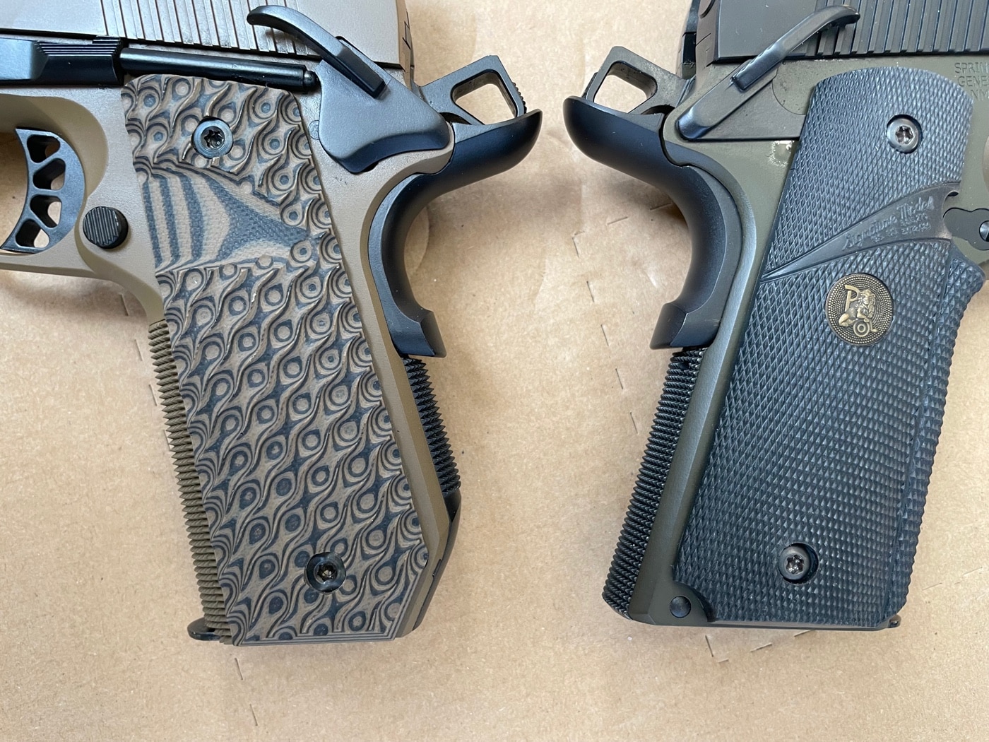 Two Springfield Armory 1911 pistol grips are shown back to back, arranged in a mirrored fashion. One grip features the standard 1911 design, while the other has the Carry Contour cut with a rounded edge. The Carry Contour grip is visibly shorter and curved, designed to reduce printing when concealed. This comparison emphasizes the ergonomic and concealment advantages of the Carry Contour modification.