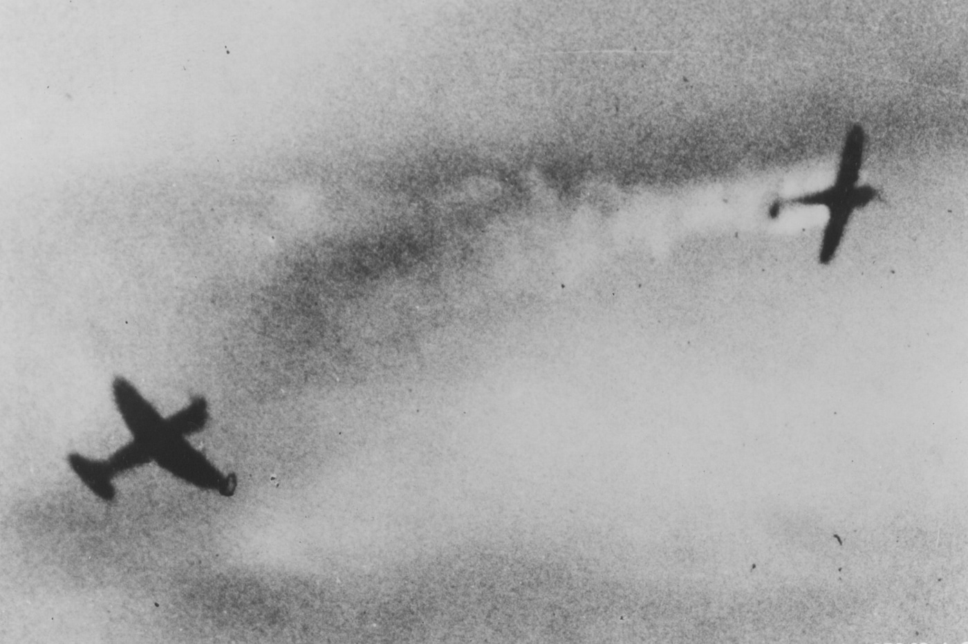 The gun camera of a Republic P-47 records another Thunderbolt firing its weapons, successfully shooting down a Messerschmitt Me 109. The image captures the critical teamwork and combat efficiency that defined the Allied air strategy. It showcases the Thunderbolt’s role not just as an individual powerhouse, but as part of a cohesive fighting force. This scene represents the skill and bravery of the pilots who faced danger to ensure victory.