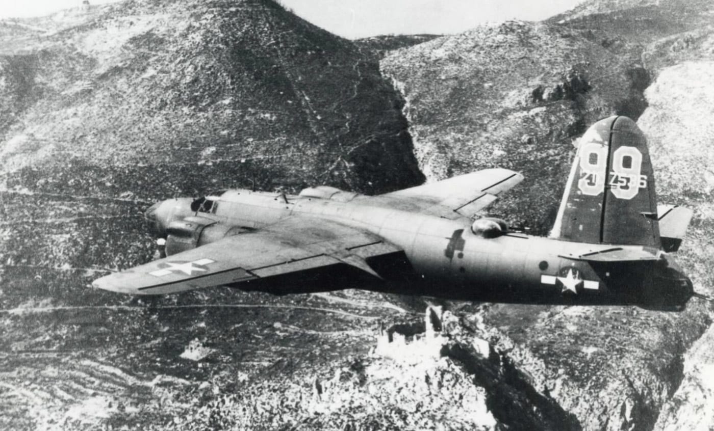 A B-26 Marauder aircraft, serial number 42-107536, from the 17th Bomb Group of the 12th Air Force, flies past the ruins of Monte Cassino Abbey during the Battle of Monte Cassino in 1944. The aircraft is captured in mid-flight against a backdrop of the heavily bombed and crumbled monastery atop Monte Cassino. The abbey's ruins reflect the devastation caused by Allied bombing in an effort to weaken German defensive positions on the Gustav Line. The B-26 Marauder was a medium bomber used extensively in the Italian Campaign for precision strikes. This photograph illustrates the critical role of airpower in the prolonged and costly battle. It also underscores the significant destruction endured by one of Italy's historic landmarks during World War II.