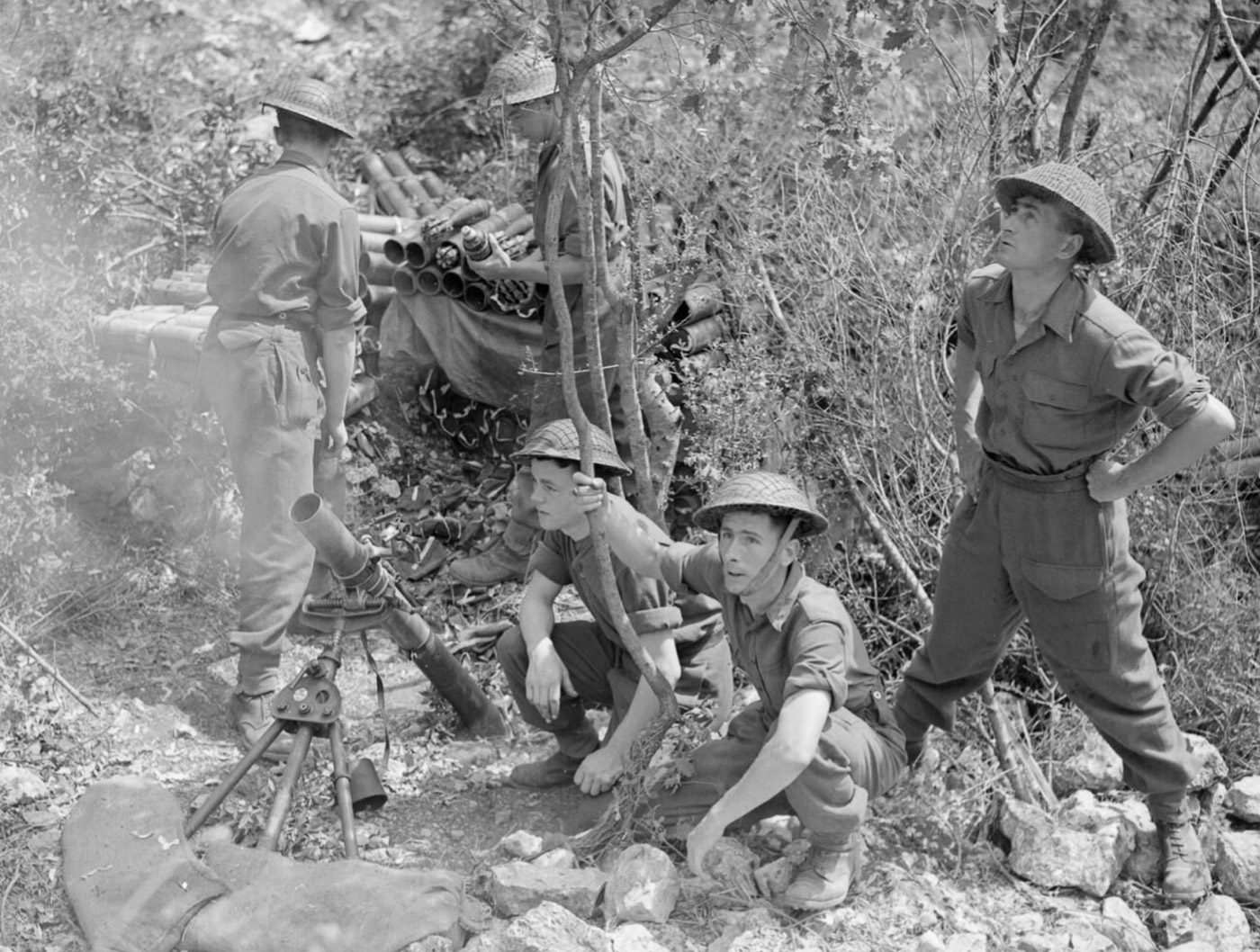 A 3-inch mortar crew from No. 2771 Field Squadron of the RAF Regiment fires at enemy positions from a ravine on the Colle Belvedere, north of Cassino, during the Battle of Monte Cassino. The soldiers work methodically, surrounded by rugged terrain that provides both cover and challenges in the midst of the intense fighting. The mortar's high-explosive rounds were vital in targeting German fortifications along the Gustav Line. The ravine setting emphasizes the strategic use of natural features in the Allied advance during the Italian Campaign. This image showcases the critical role of artillery support in overcoming entrenched German resistance at Monte Cassino.