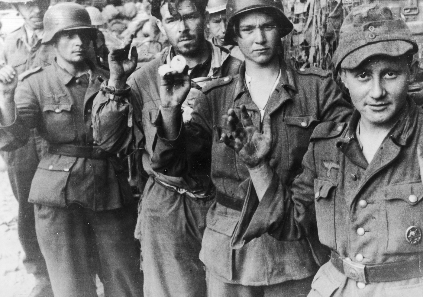 German prisoners of war, captured by Polish soldiers during the Battle of Monte Cassino, stand in a group under Allied supervision. The expressions on their faces reflect exhaustion and resignation after the intense fighting along the Gustav Line. Polish troops played a decisive role in the final assaults that led to the capture of Monte Cassino, contributing significantly to the Allied breakthrough in the Italian Campaign. The rugged terrain and scattered debris visible in the background underscore the harsh conditions of the battle. This image highlights the pivotal role of the 2nd Polish Corps in securing victory and the human toll of the prolonged conflict