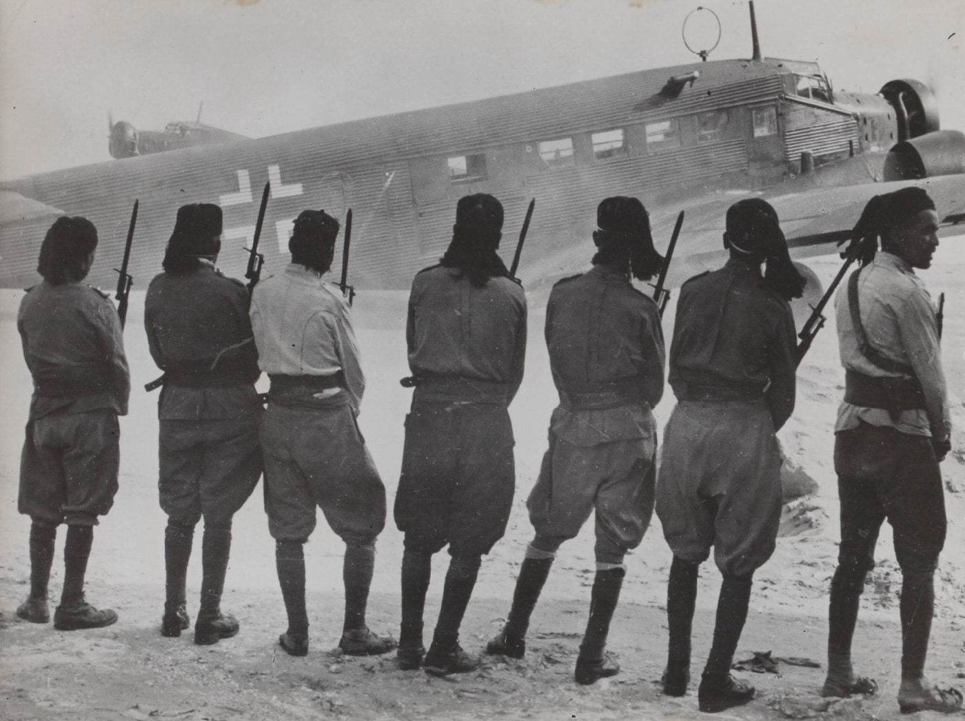 Libyan soldiers watch a Junkers Ju 52 deliver aircraft parts