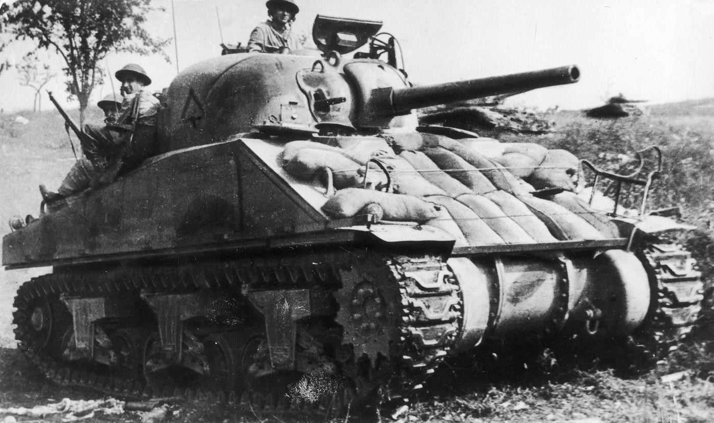 An M4 Sherman tank of the Independent 2nd Armored Brigade, part of the 2nd Polish Corps, advances during the Battle of Monte Cassino. Commanded by Lieutenant Edward Budzianowski, the tank moves toward the "Gardziela" alongside sappers to support Allied efforts against German positions. The scene reflects the critical role played by Polish forces in breaking through the heavily fortified Gustav Line. The rugged terrain and military equipment highlight the challenges faced in this intense and decisive phase of the Italian Campaign. This image underscores the bravery and contribution of the 2nd Polish Corps in the Allied victory at Monte Cassino.