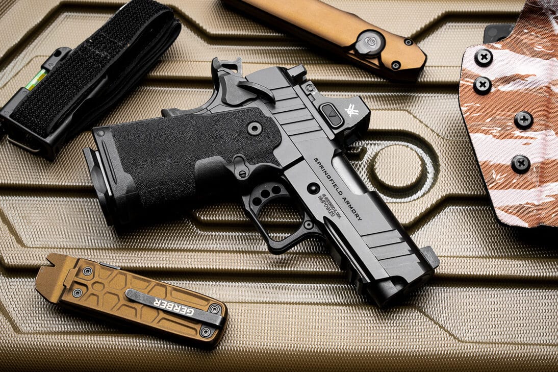 The Springfield Armory 1911 DS Prodigy Compact pistol with a 4.25-inch barrel is prominently displayed with all its features in view. The photo highlights the Adaptive Grip Texture on the polymer grip, the match-grade bull barrel for enhanced accuracy, and the lightweight forged aluminum frame. The extended frame-mounted safety selector and beavertail grip safety offer intuitive control and added safety. The front tritium sight and serrated rear sight provide superior aiming capabilities. The pistol's design reflects a perfect blend of modern innovation and classic 1911 reliability.