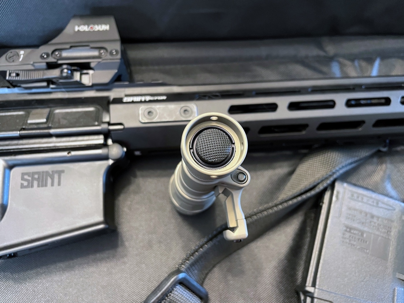 A close-up image of the tailcap switch on the SureFire Mini Scout Pro flashlight, showcasing its ergonomic and durable design. The switch is positioned for easy activation with a natural thumb motion, allowing for intuitive use during tactical or defensive situations. The protected design helps prevent accidental activation, while the rugged construction ensures long-lasting performance. The tailcap integrates seamlessly with the flashlight’s compact aluminum body, emphasizing its practical and tactical utility. This feature is crucial for maintaining control in high-stress environments.