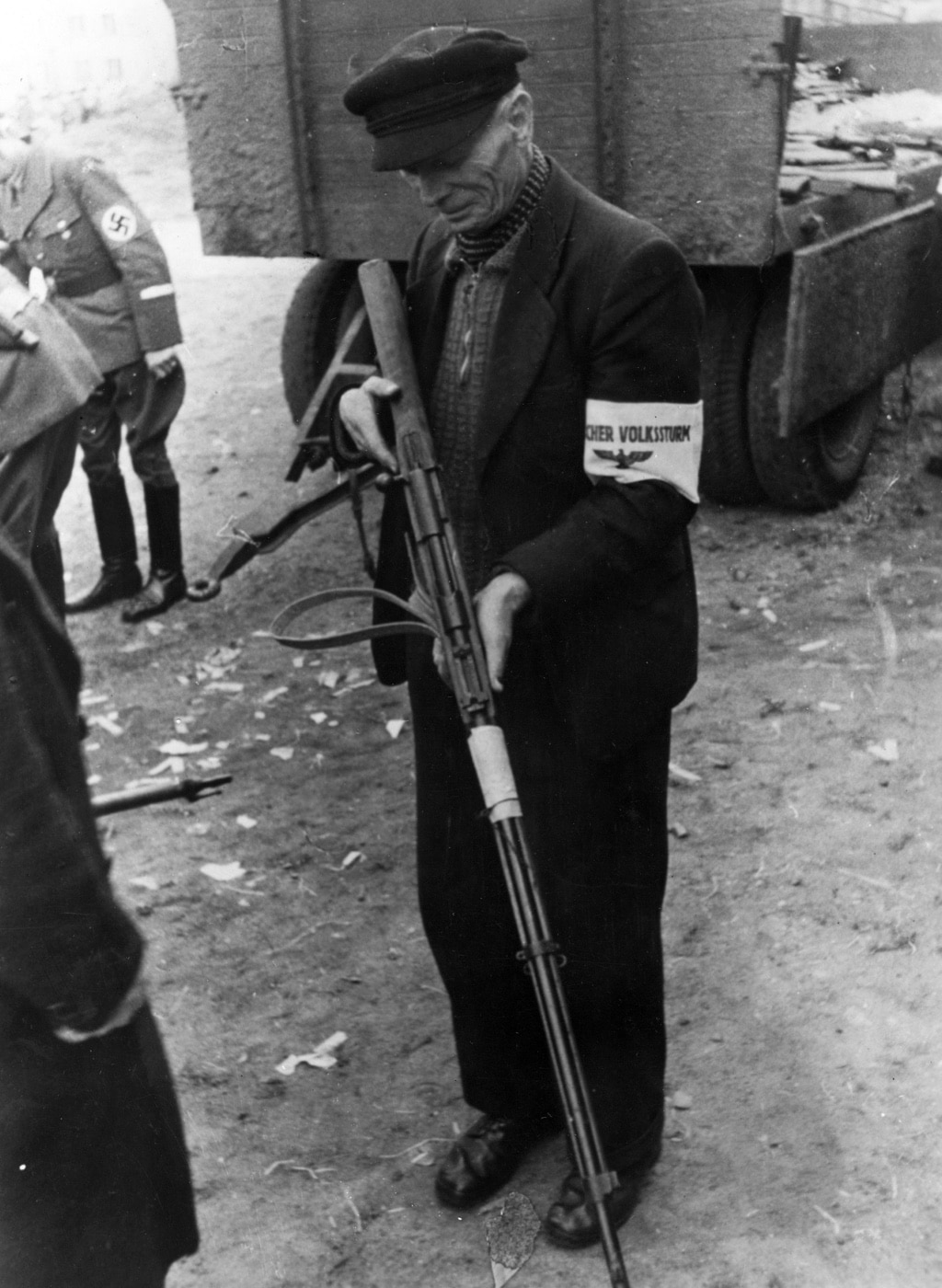 elderly Volkssturm man holds Mannlicher M1888 rifle chambered in 8x52R