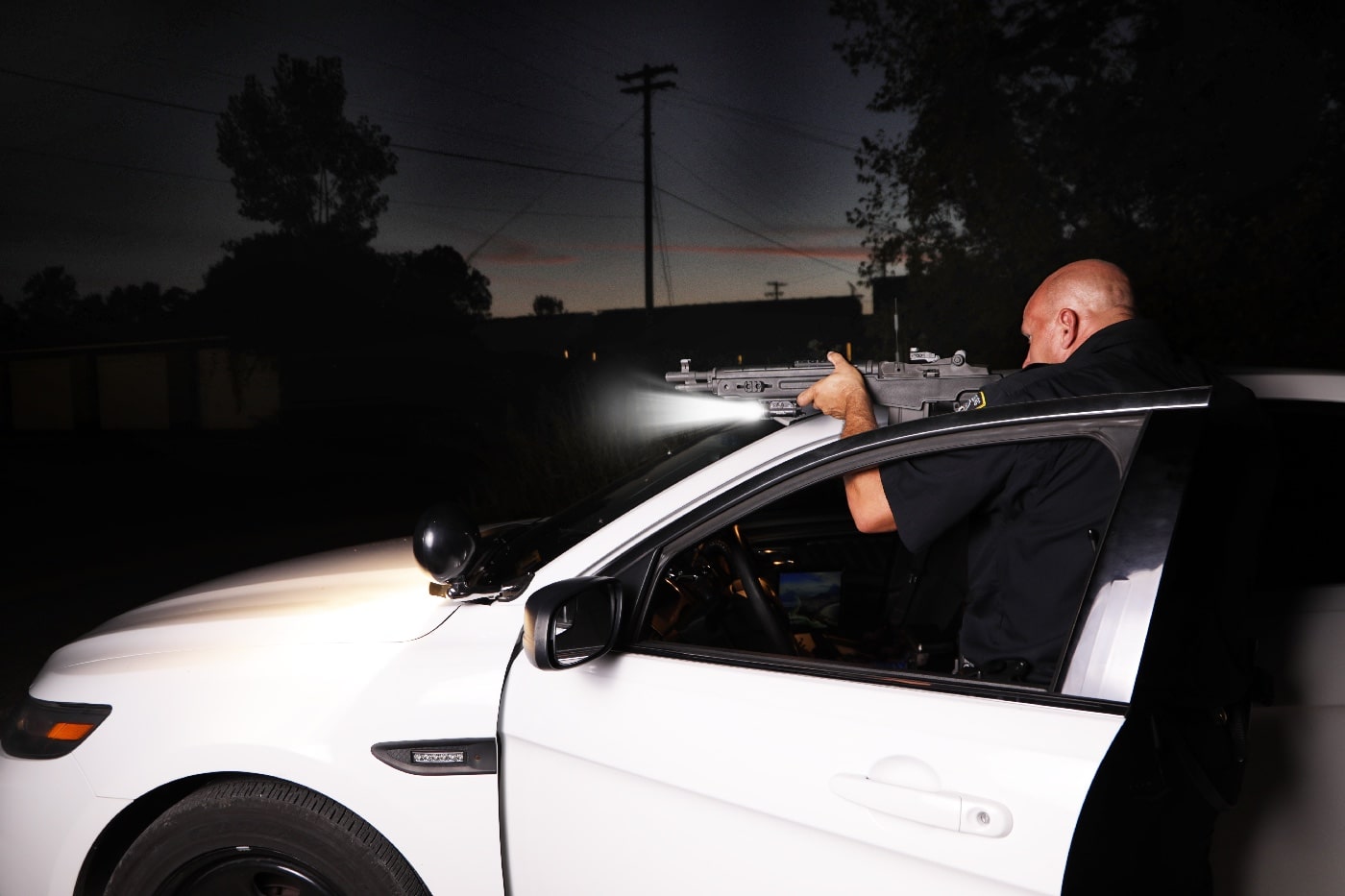 police officer using patrol car for cover