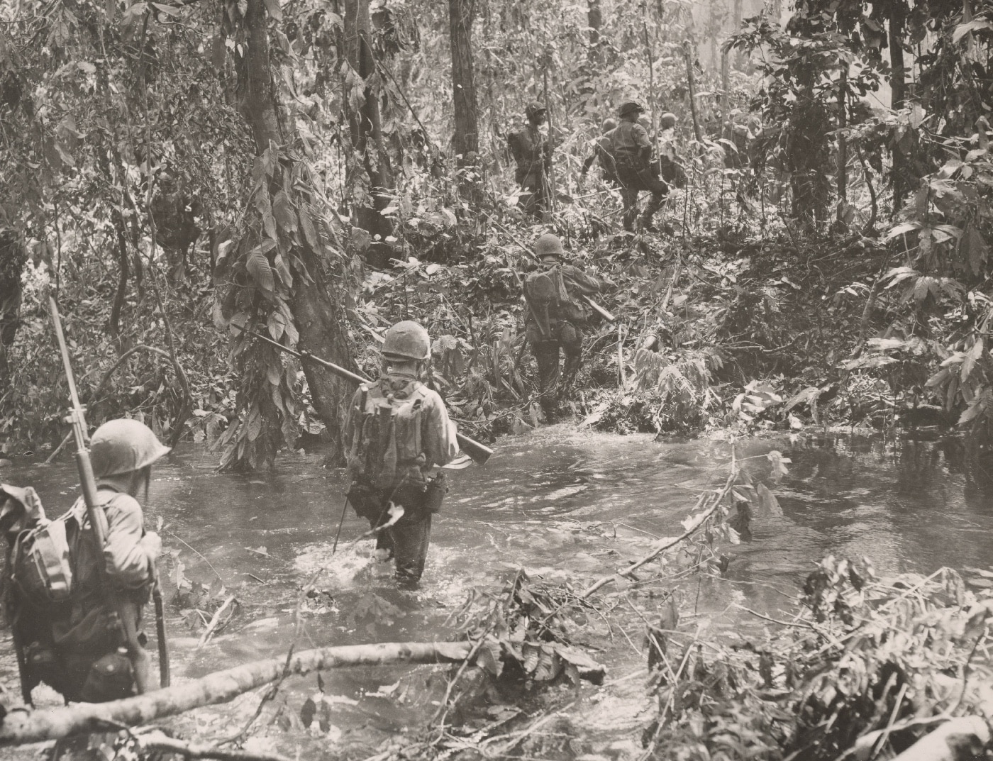 Marines cross a stream on Cape Gloucester