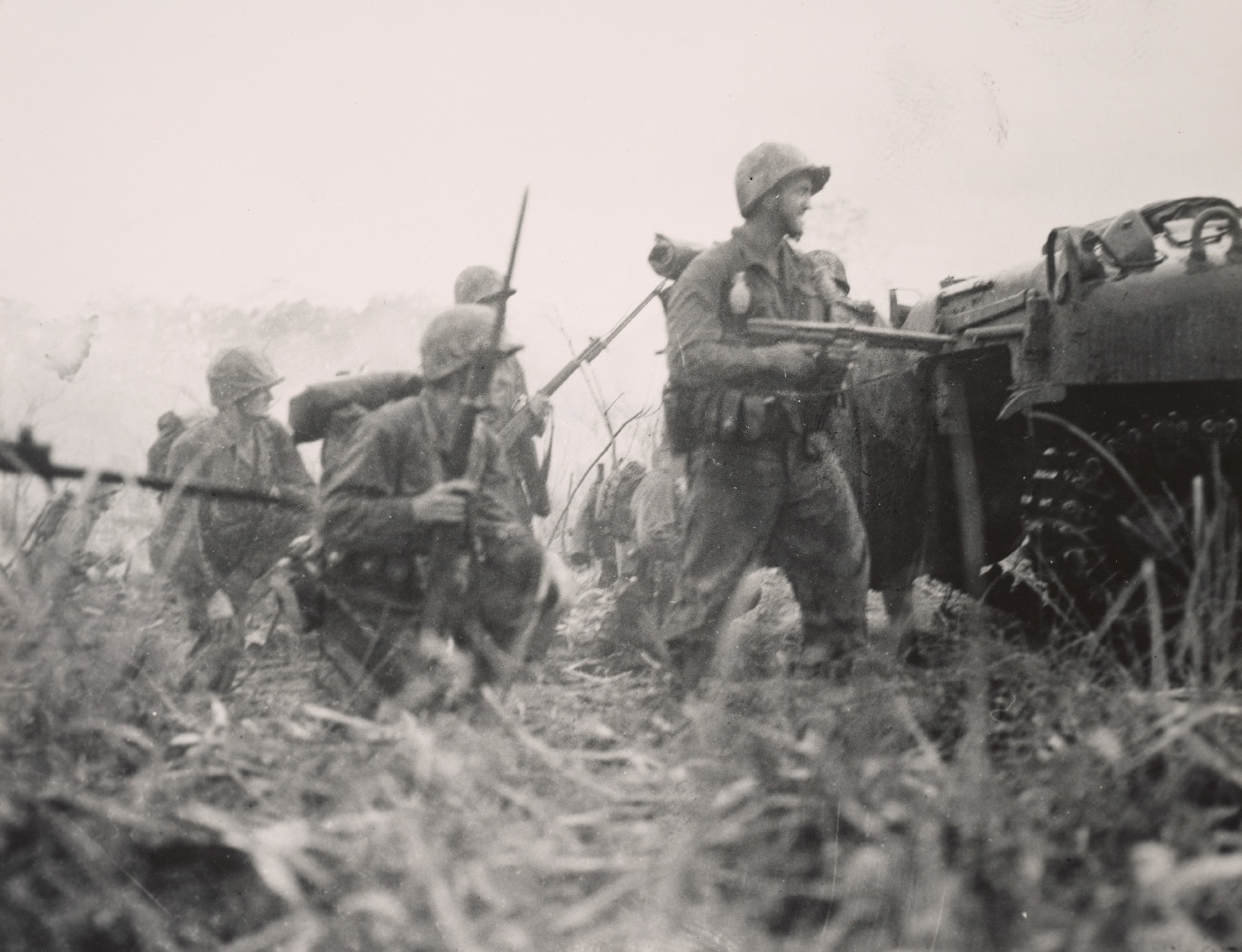 US Marines follow an M4 Sherman tank in an attack on the Japanese airport on Cape Gloucester