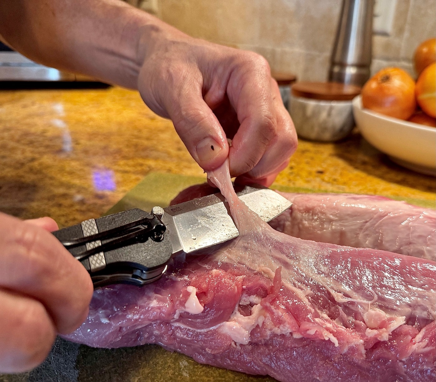 author using Ripsnort II to trim meat for cooking