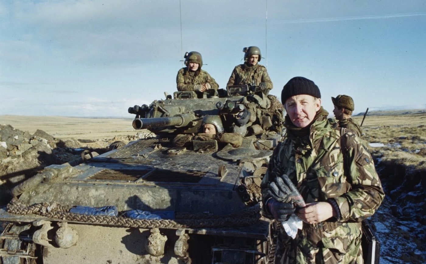 civilian reporter Michael Nicholson stands near a FV101 Scorpion light tank during the Falklands War