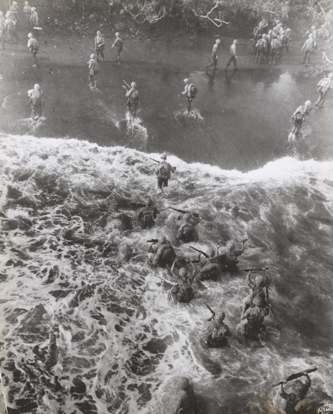 overhead view of Marines wading onto the shore at Cape Gloucester