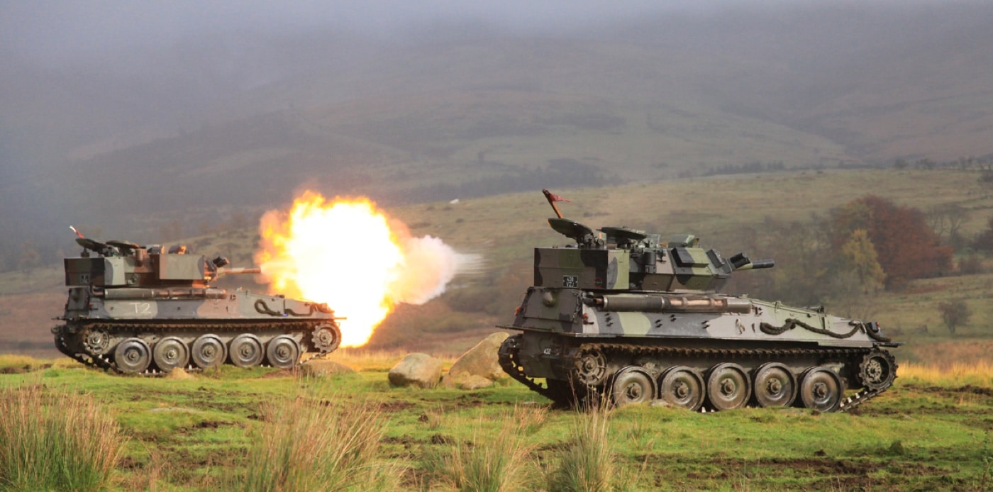 two FV101 Scorpion tanks on the shooting range practicing firing the main guns