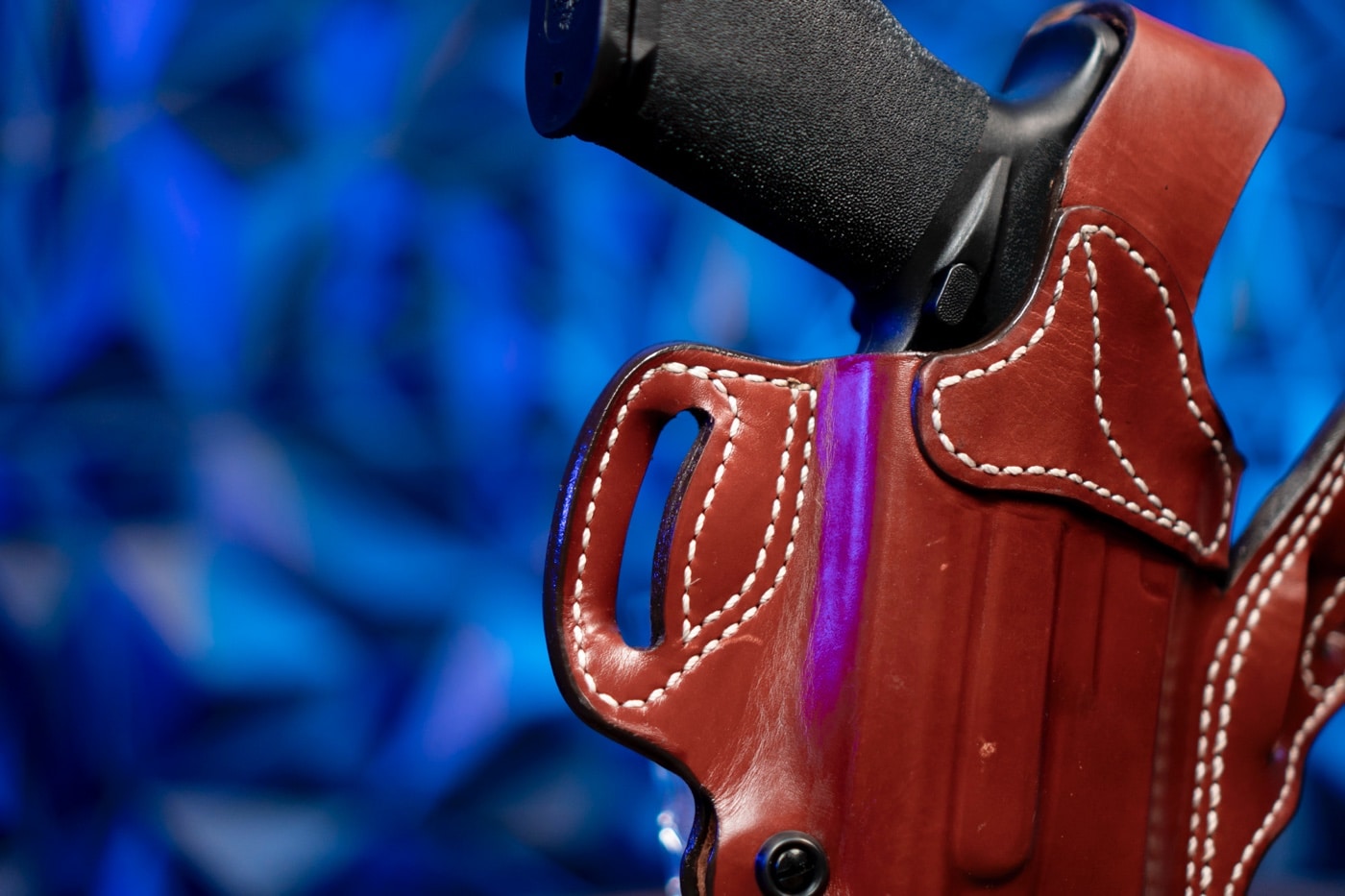 This detailed image displays the exquisite stitching around the belt loops of the DeSantis T.B. Vengeance holster, crafted from American full grain steer leather. The photo clearly illustrates the triple stitching and reinforced belt slots, essential for excellent weapon retention and secure concealed carry. The craftsmanship showcased here is a testament to quality in leather products and gunsmithing. The holster is designed for handguns and pistols, including models like the Glock and 9mm, making it a unique holster option for law enforcement and plainclothes professionals. Keywords such as holster, handgun, pistol, concealed carry, leather, thumb break, premium leather holster, and scabbard holster are integral to this review. The close-up emphasizes multiple carry positions, additional strength from the added thumb break, and the minimalist design that appeals to sport shooting enthusiasts. This detailed view aids visually impaired users in understanding the superior build quality and refined craftsmanship of the DeSantis T.B. Vengeance holster review.