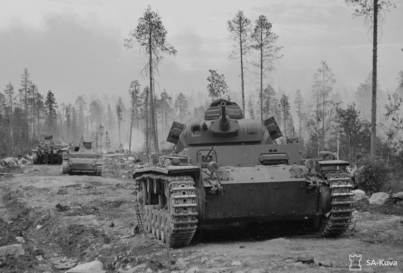 This photo captures a dramatic moment in 1941 as German Panzer III tanks, also known as Panzerkampfwagen III or pz iii, advance toward Soviet Red Army tanks. The image shows these iconic panzers, with their prominent turret and main armament, moving in formation as part of the mechanized troops of Nazi Germany. In the background, Soviet armored forces, including hints of KV-1 heavy tanks, illustrate the fierce armored warfare on the Eastern Front. The scene evokes the brutal tactics of blitzkrieg, reminiscent of the strategies seen in battles such as Kursk and Stalingrad. Detailed views of armor plates and the turret ring underscore the engineering prowess behind these vehicles and highlight the historical impact of German armored divisions during World War II.