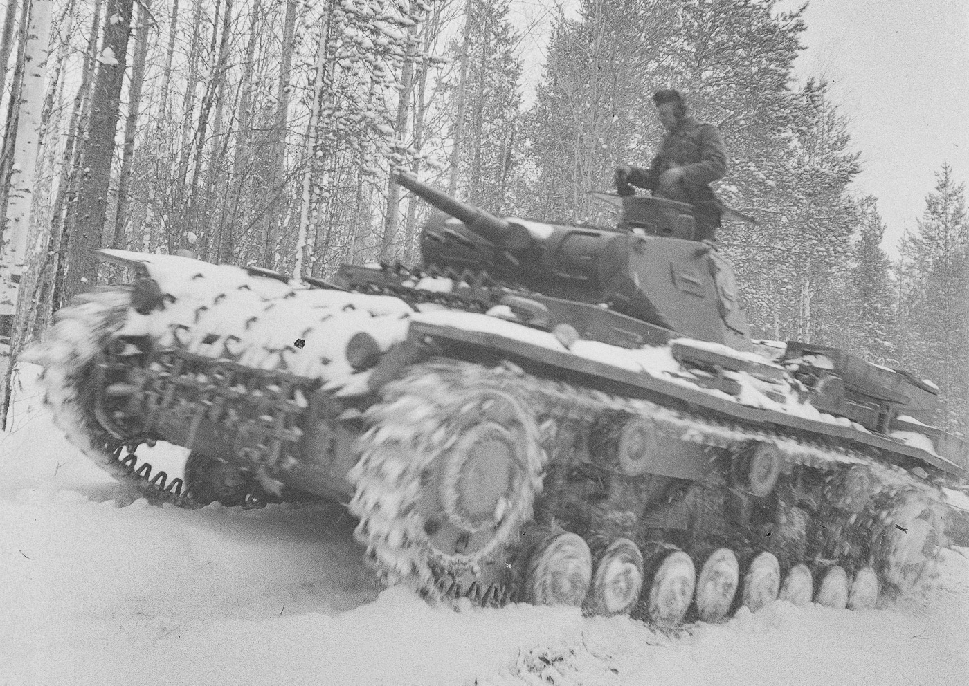 This photo depicts a German Panzer III tank, also known as Panzerkampfwagen III or pz iii, advancing through a snowy landscape near Kiestinki in the direction of Jelettijärvi during the Continuation War in 1942. The image highlights the tank’s prominent turret, main armament, and rolled homogeneous armour as it moves with determination in harsh winter conditions. As an integral part of German armored forces and panzer divisions, this vehicle symbolizes the evolution of armored warfare and the tactical prowess of Nazi Germany’s mechanized troops. The scene evokes memories of blitzkrieg tactics and major battles, resonating with the legacy of engagements like the battle of Kursk and the fierce encounters against Soviet forces. Detailed features such as the turret ring and assembly line craftsmanship, attributed to Rheinmetall, underscore the engineering excellence behind these historic vehicles. The photograph offers a vivid portrayal of armored fighting vehicles in action, reflecting the strategic interplay of technology and warfare during World War II.