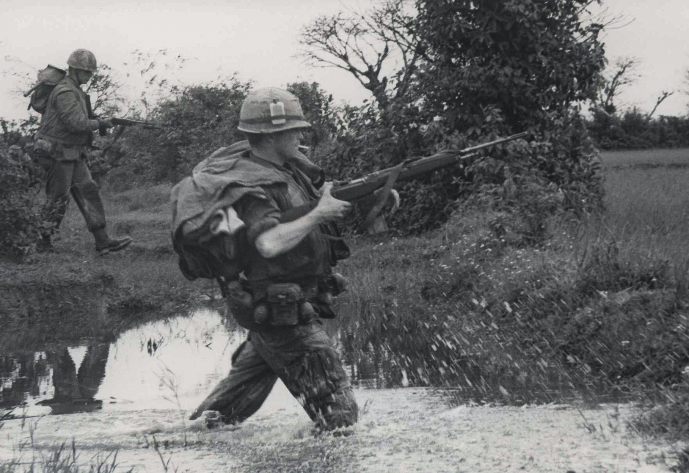 US Marine crosses stream in Vietnam carrying M14 rifle