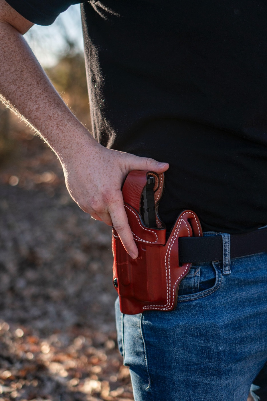 This image features the author demonstrating the thumb break mechanism on the DeSantis T.B. Vengeance holster, highlighting its unique retention design. The author’s hand is shown engaging the thumb break to allow for a smooth draw of the firearm. The holster is crafted from premium American full-grain steer leather with impeccable stitching and reinforced belt loops. This demonstration provides an in-depth look at the thumb break’s functionality, making it ideal for both concealed carry and open carry applications. The design incorporates a secure retention system that appeals to users looking for reliable firearm retention and advanced holster technology. Keywords such as holster, handgun, pistol, concealed carry, thumb break, premium leather holster, and review desantis are included to emphasize its features. This detailed description is intended to help visually impaired users understand the operational mechanics and superior build of the holster.