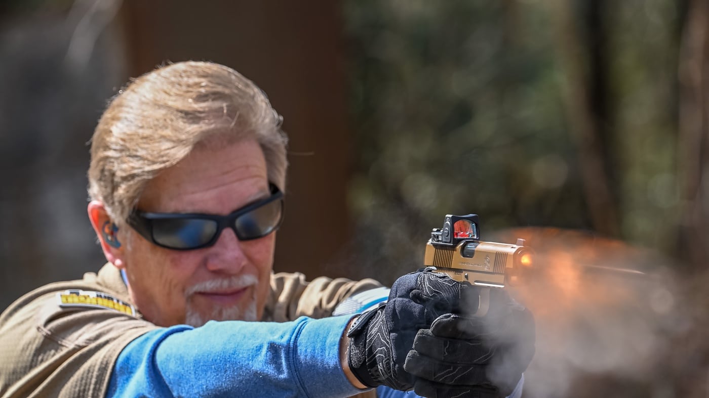 bullet leaving barrel of 1911 pistol