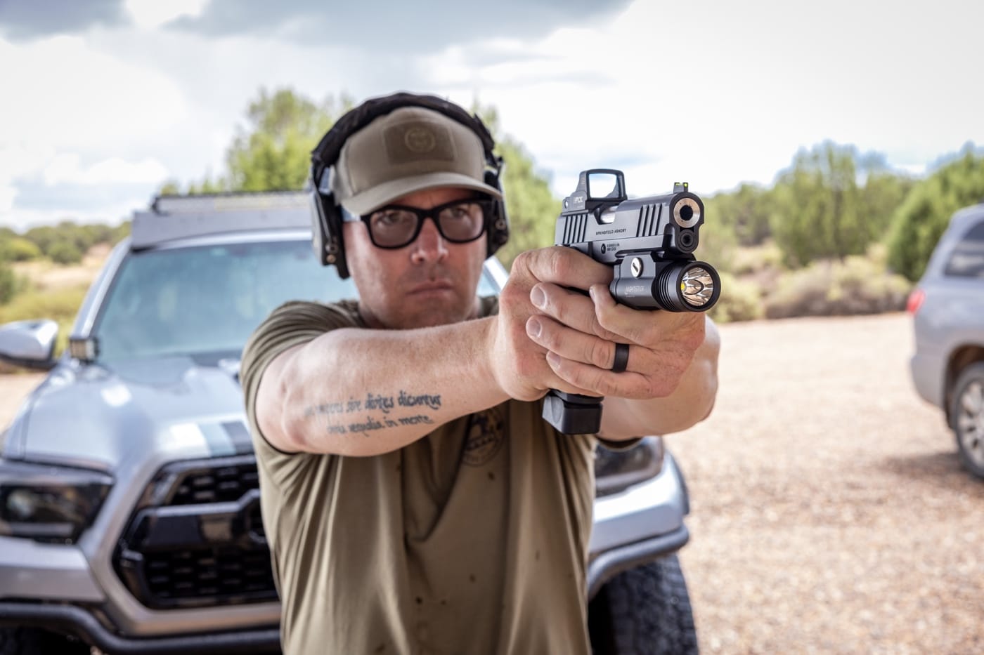 This photograph depicts a man wearing prescription shooting glasses training with his classic 1911 pistol at a modern shooting range. It highlights the importance of shooting sports and target shooting for senior citizens and older adults. The shooter focuses on improving his grip safety, trigger control, and overall accuracy while practicing with his firearm. His training session embodies elements of active shooter training and concealed carry techniques, emphasizing the need for proper training and self-defense. The image reflects how aging challenges such as arthritis and reduced motor skills can be managed through resilient practice and adjustments. It also underscores the value of home defense and self-protection strategies using a handgun and pistol.